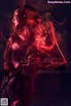 A woman with a sword in her hand and a red light coming out of her body.