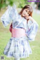 A woman in a blue and pink kimono posing for a picture.