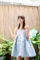 A woman in a blue dress holding a piece of cake.