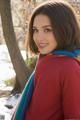 A woman in a red sweater and a colorful scarf.