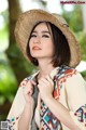 A woman wearing a straw hat and a colorful scarf.