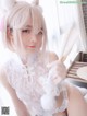 A woman in a white lingerie holding a fan.